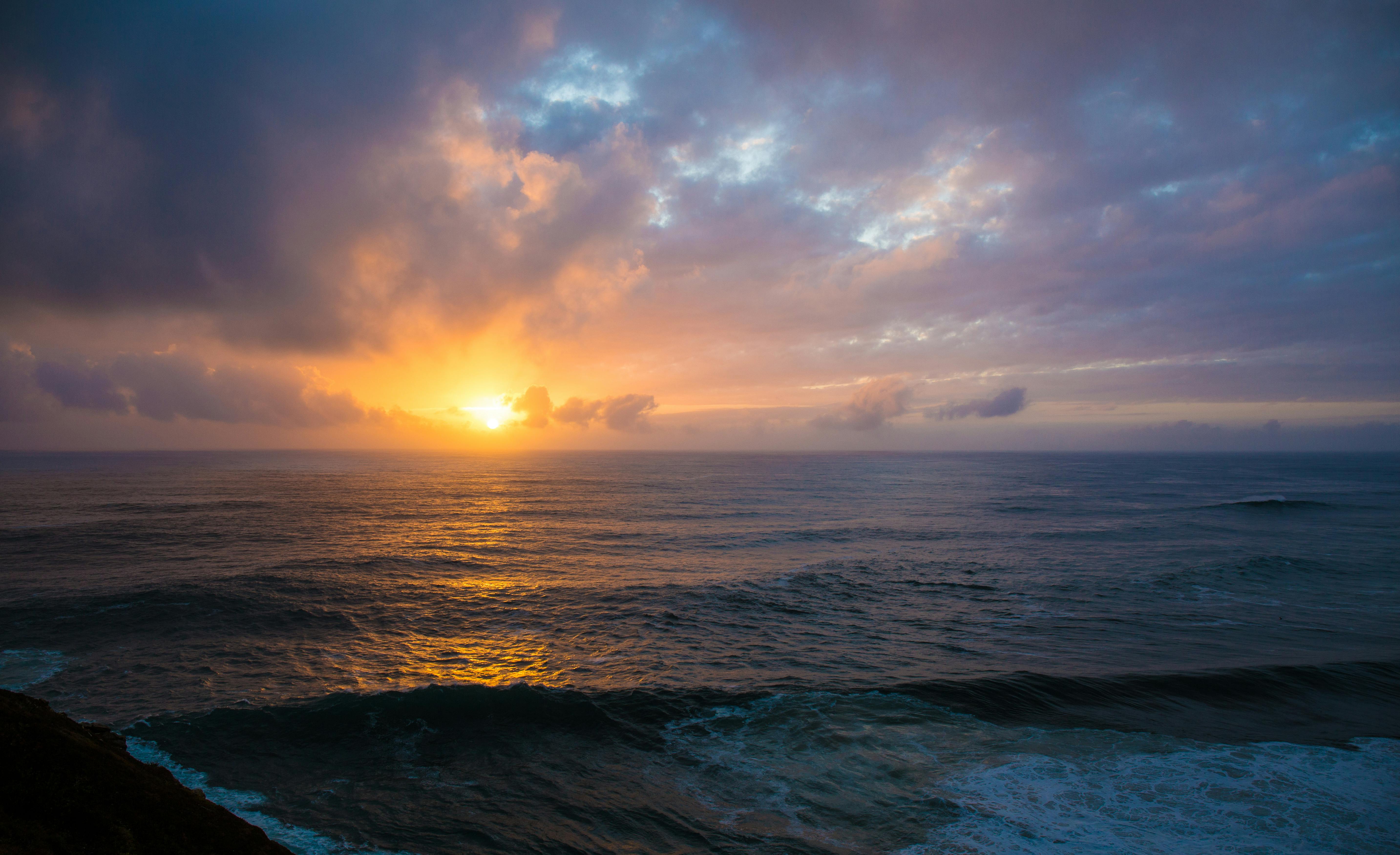 Serene ocean view at sunset with vibrant colors and calm waves, perfect for peaceful moments.