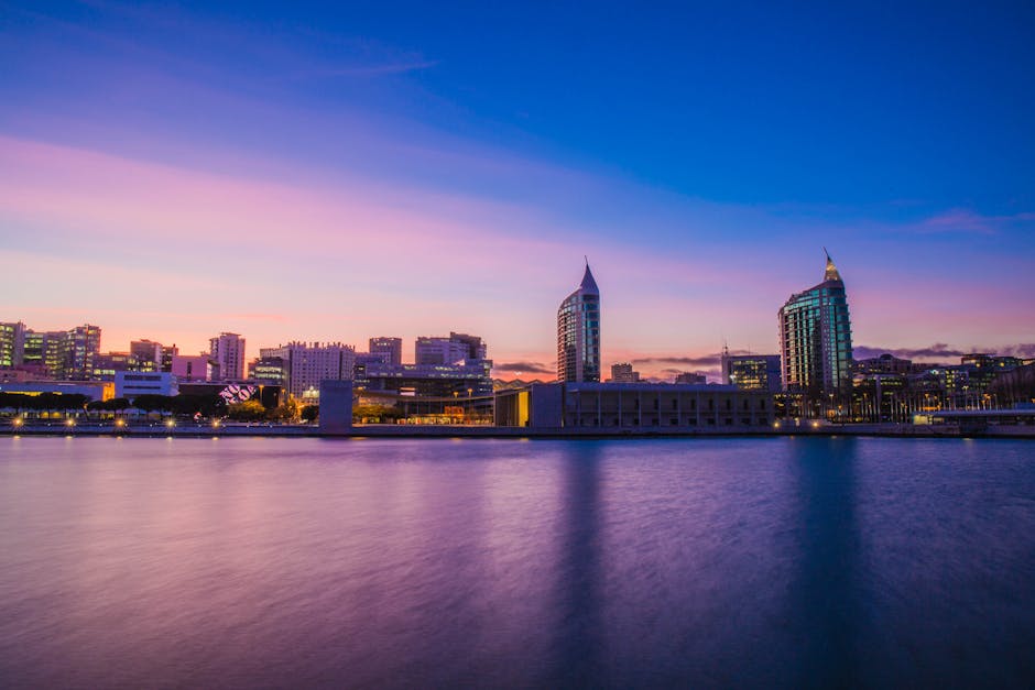 Beautiful cityscape of Lisbon at dusk featuring modern architecture and waterfront view.