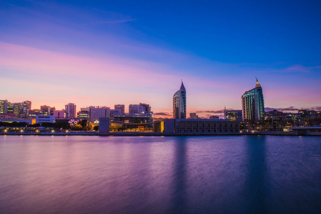 Beautiful cityscape of Lisbon at dusk featuring modern architecture and waterfront view.
