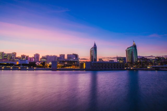 Beautiful cityscape of Lisbon at dusk featuring modern architecture and waterfront view.
