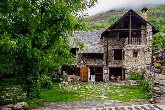 Beautiful stone house surrounded by lush greenery in a scenic countryside setting.
