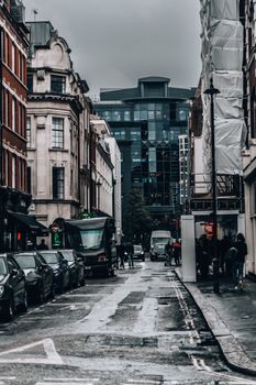 Scenic view of a rainy street in London showcasing a blend of historic and modern architecture.