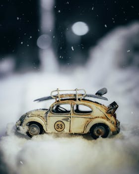 Close-up of a vintage toy car in the snow, evoking nostalgic winter vibes.