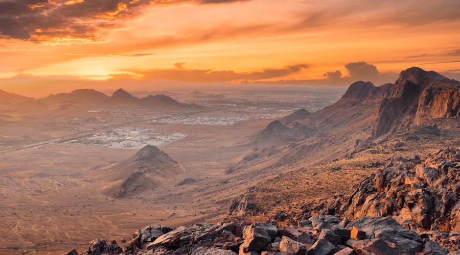 Rocky mountains above Madinah at sunset with the city spread out on the plain below