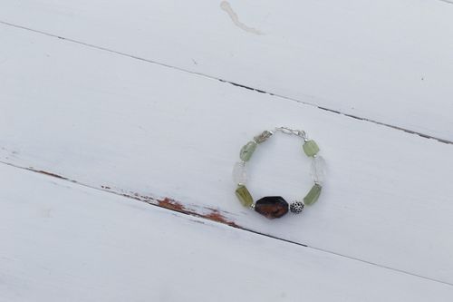 Free A stylish crystal bracelet with jade and colored beads on a rustic wooden surface. Stock Photo
