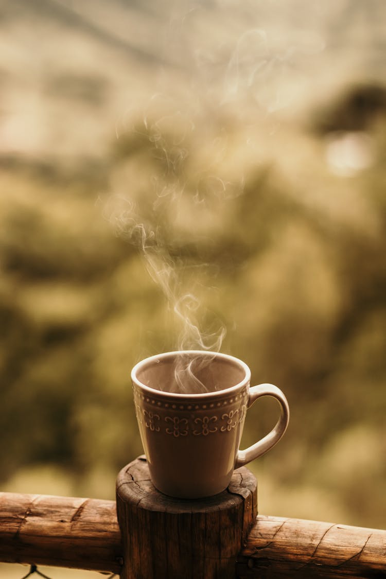 Steaming Mug Of Coffee On Wooden Coaster 