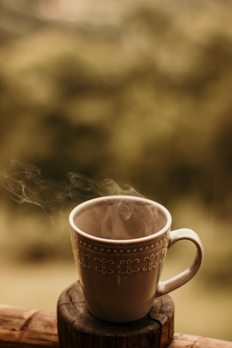 Steaming Mug Of Coffee On Wooden Coaster 