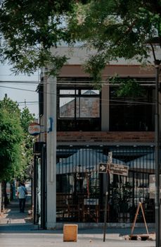 Explore a vibrant urban street scene featuring a charming outdoor cafe with lush greenery.