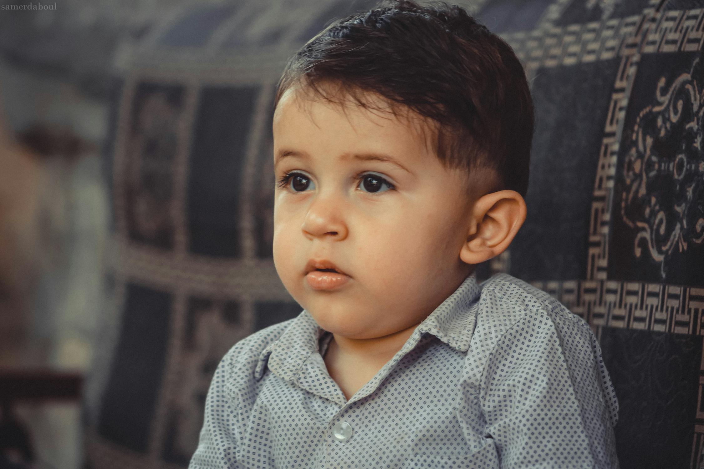 Boy in Gray Button-up Shirt Sitting on Black Sofa · Free Stock Photo