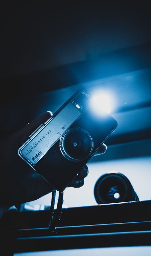 Free A vintage Kodak camera held in hand with blue light effect in São Paulo, Brazil. Stock Photo