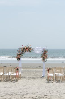 Beautiful beach wedding setup with floral arch on Coronado's serene shore, capturing a scenic ceremony ambiance.