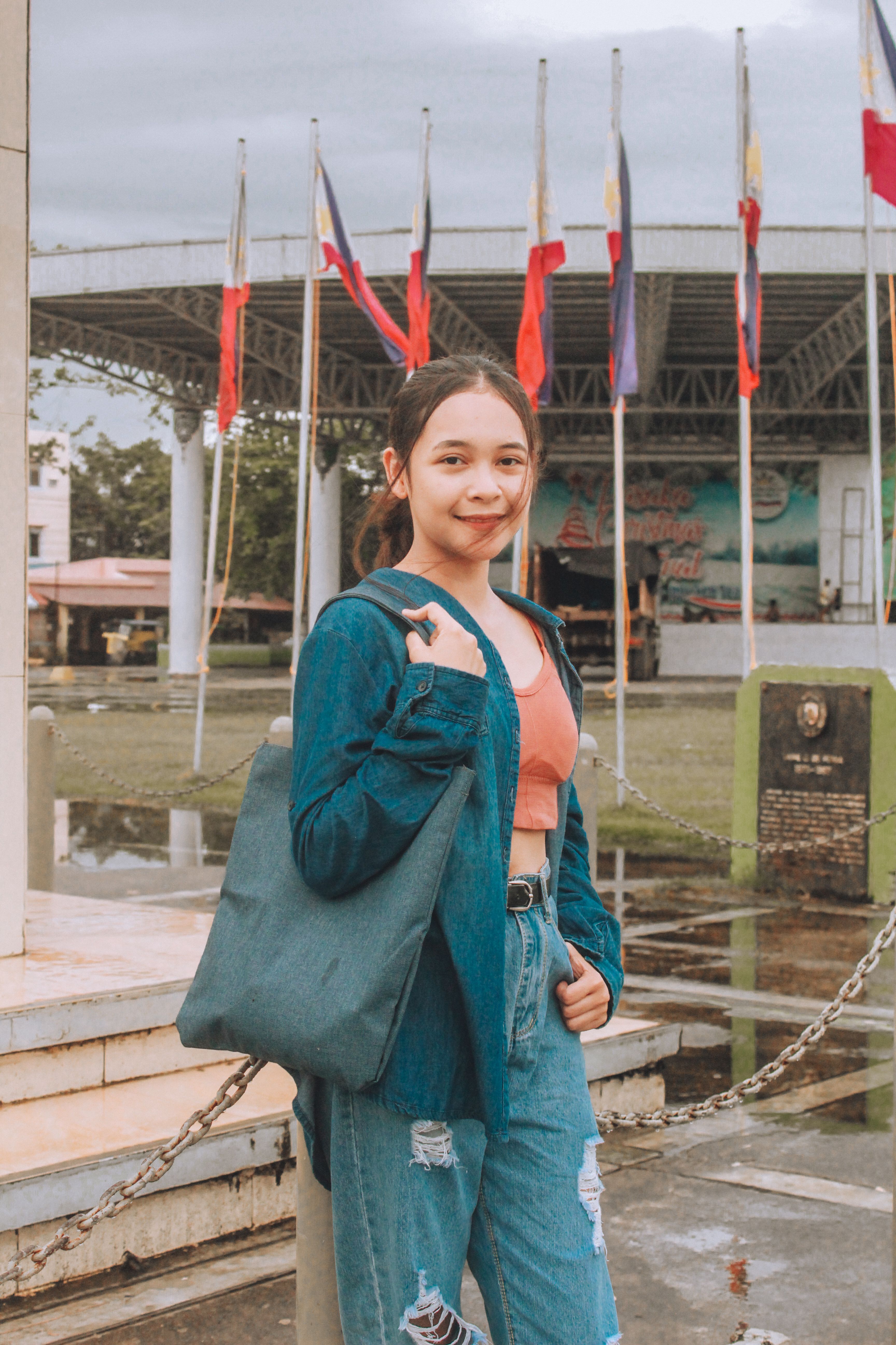 A Woman in Blue Coat Holding a Tote Bag · Free Stock Photo