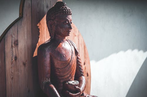 A Brown Wooden Statue of Buddha