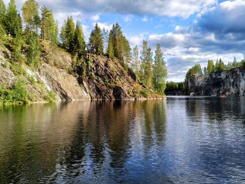 Free Stunning view of a serene lake with rocky cliffs and trees in Karelia, Russia. Stock Photo