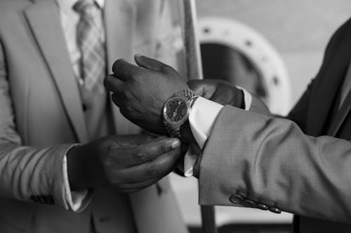 Grayscale Photo of a Person in a Suit Wearing a Wristwatch