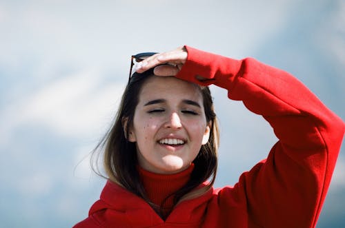 Free Smiling Woman in Red Hoodie Looking Afar Stock Photo