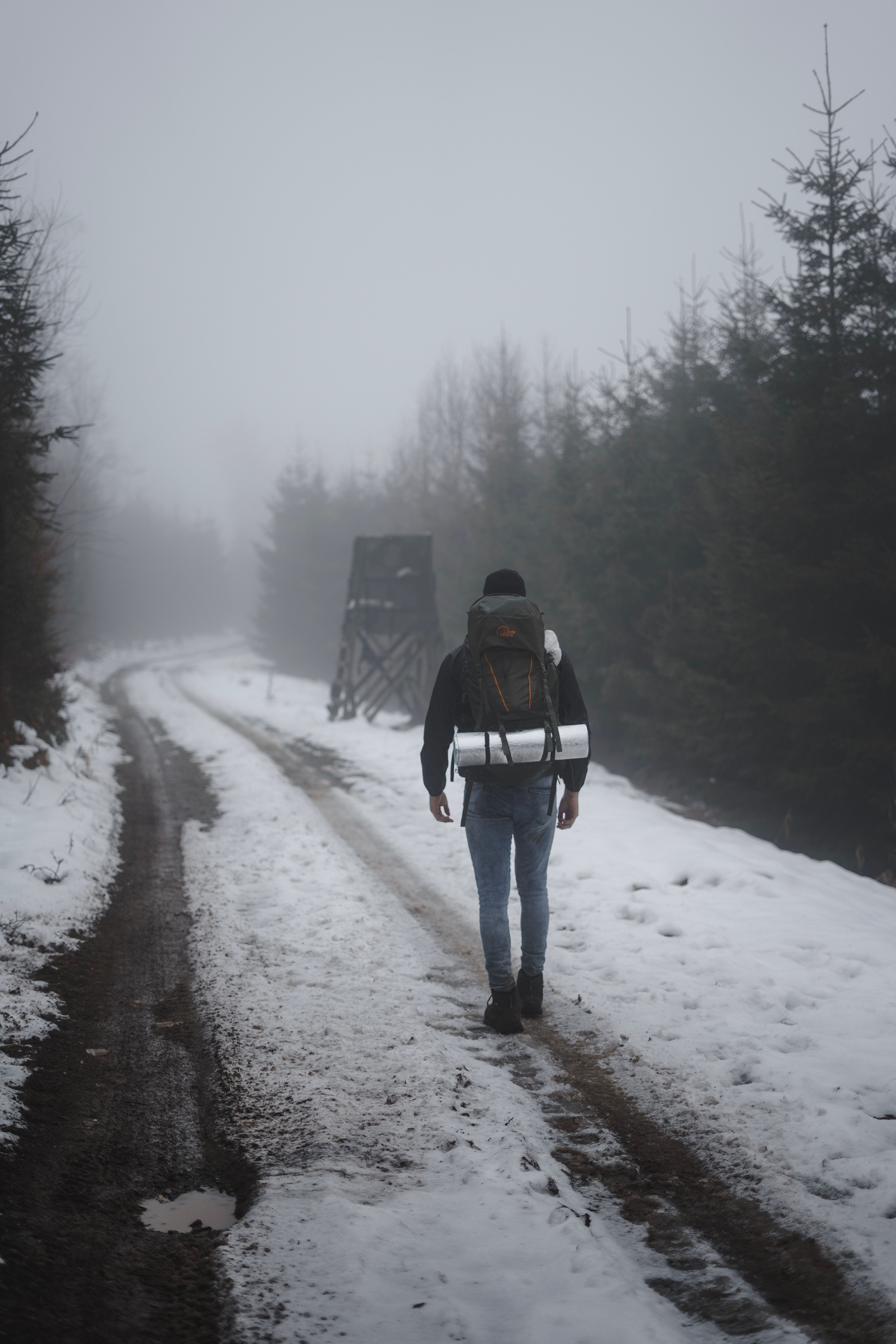 A Person Walking on Snow Covered Road · Free Stock Photo