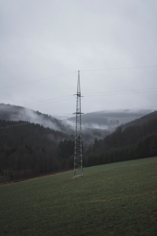 Free Power Pylon Standing on Misty Hill  Stock Photo