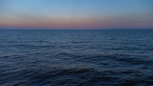 Free Calm ocean waters meeting the serene horizon at sunset, capturing nature's tranquility off Brazil's coast. Stock Photo
