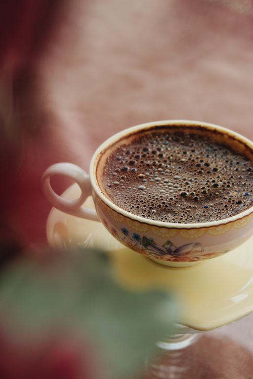 Free Close-up of a steaming coffee in a delicate floral cup with saucer. Stock Photo