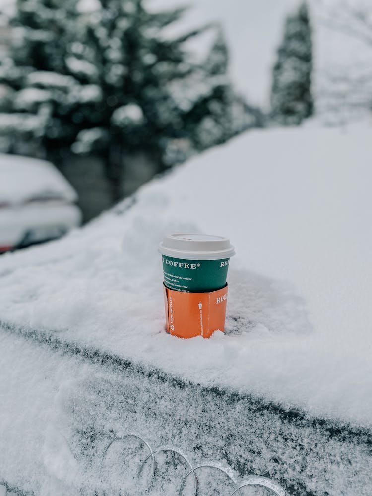 A Coffee Cup On A Snow Covered Audi Car