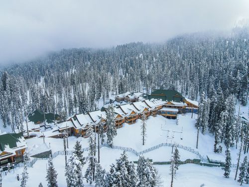 Free Beautiful aerial view of a snow-covered resort surrounded by a foggy forest in winter. Stock Photo