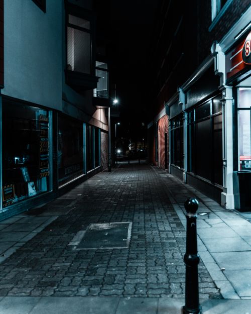 Free A dark, moody night scene of a narrow alleyway in Gloucester, England, showcasing urban architecture. Stock Photo
