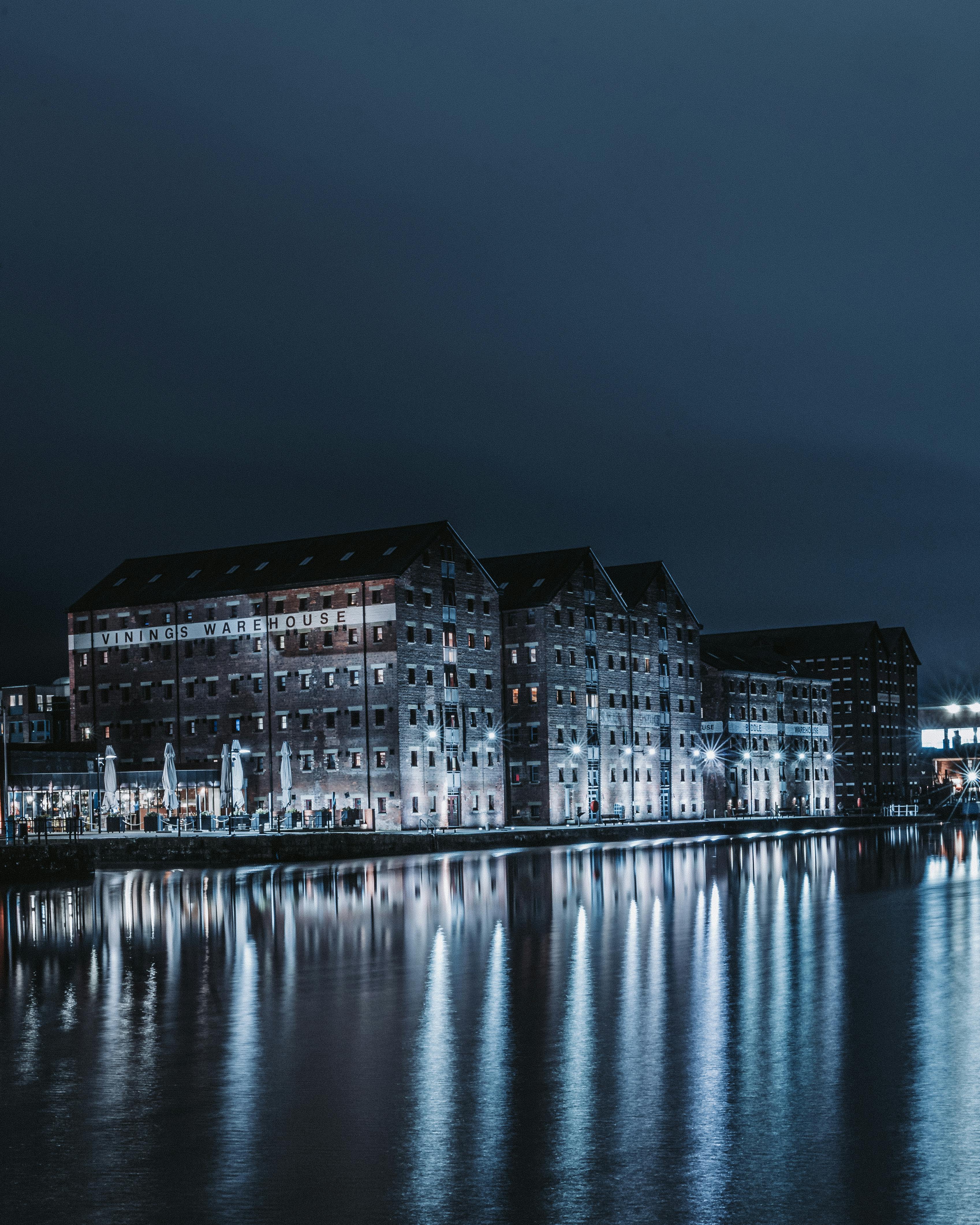 Illuminated buildings reflecting on water at Gloucester Docks, England.