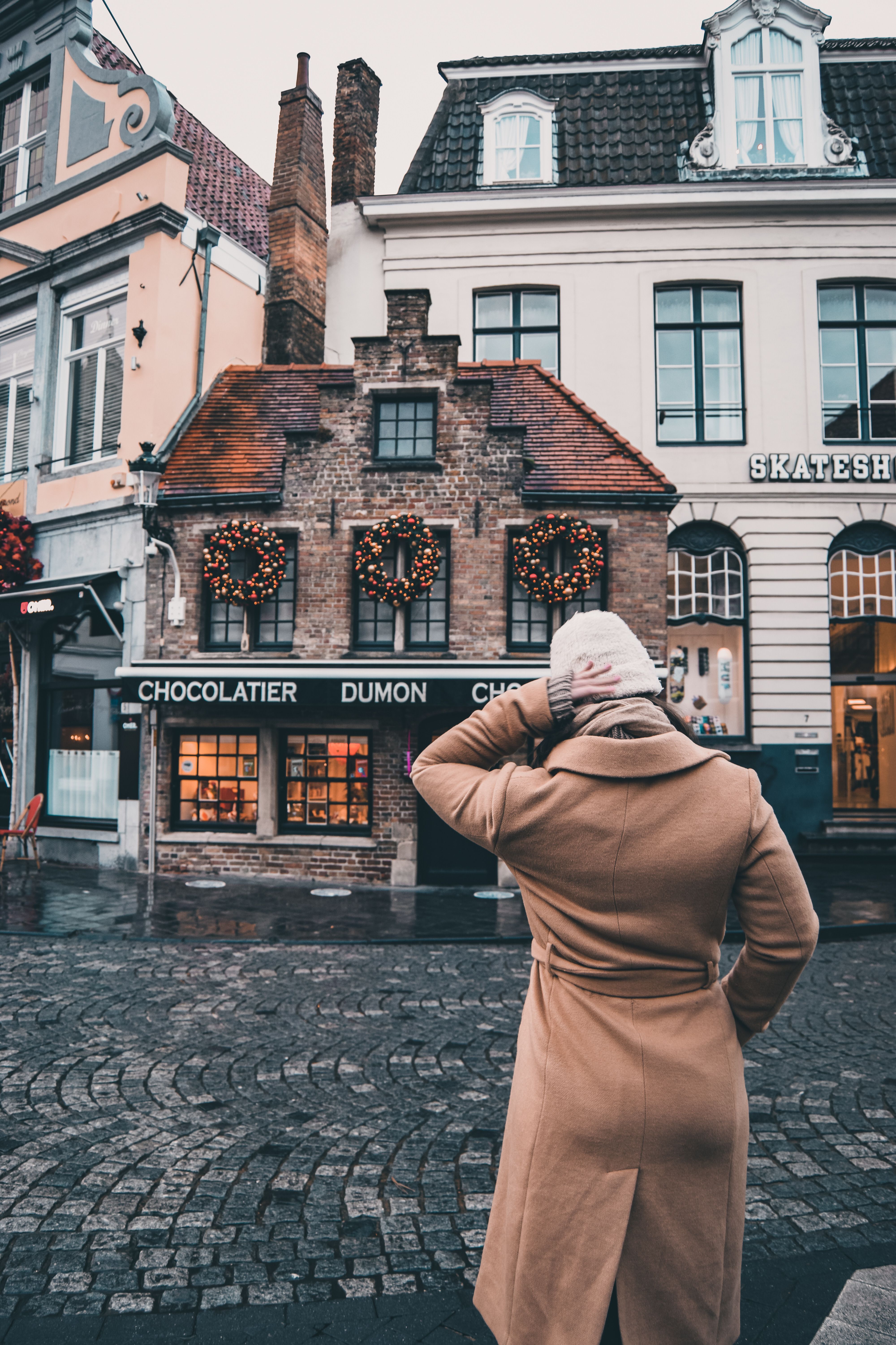 Person in Brown Coat Standing in Front of Brown Building · Free Stock Photo