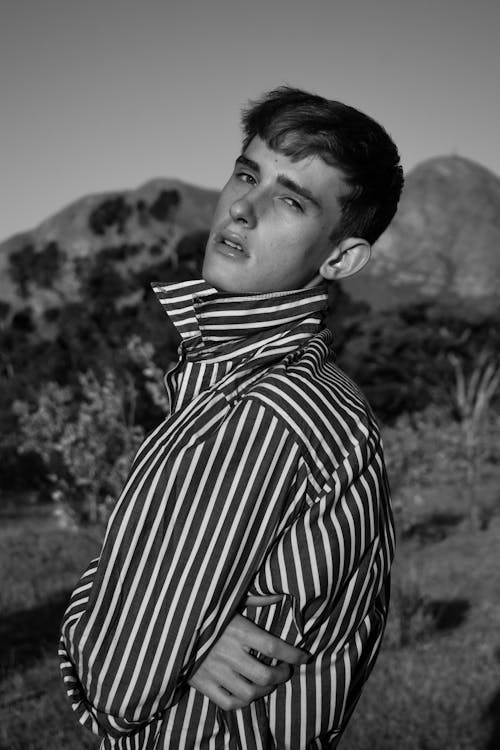 Grayscale Photo of Man in Striped Long Sleeve Shirt