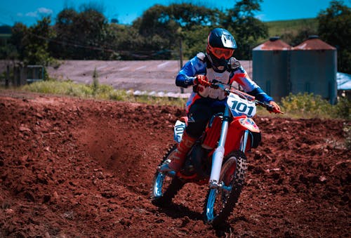 A Person in Blue and White Long Sleeve Shirt Riding a Motorbike