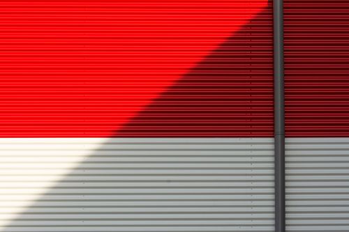 Free Bright red and white corrugated metal wall with dramatic shadow effect. Stock Photo