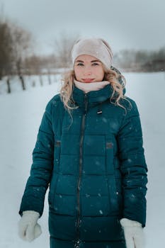 Woman in warm clothing enjoying a snowy winter day.