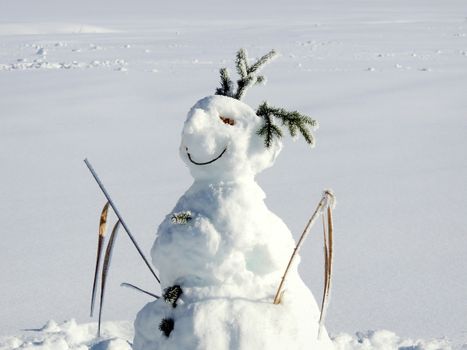 A cheerful snowman in a snow-covered field on a sunny winter day at Walchsee, Austria.