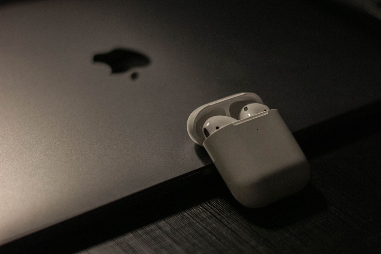 sleek wireless earbuds in a case resting on a laptop surface showcasin