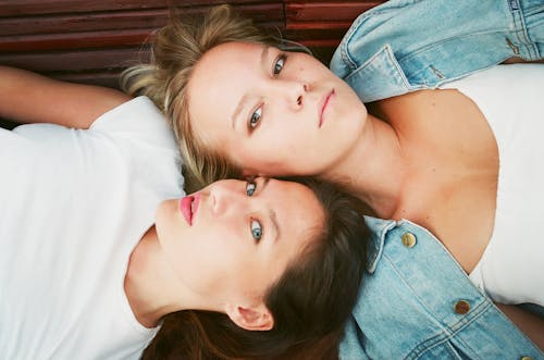 Free Two Woman Lying on Brown Surface in High Angle Photo Stock Photo