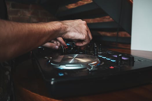 Close-up of DJ's hands mixing music on a turntable, capturing the dynamic vibe.