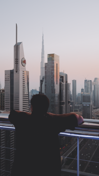 Man admiring the iconic Dubai skyline featuring Burj Khalifa at dusk.