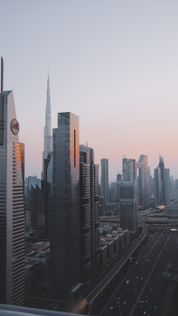 Aerial view of Dubai's skyline featuring skyscrapers and the Burj Khalifa at sunset.