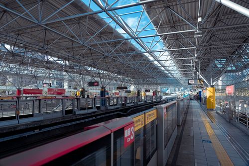 Free Spacious modern train station with lattice roof and colorful signage, empty platform. Stock Photo