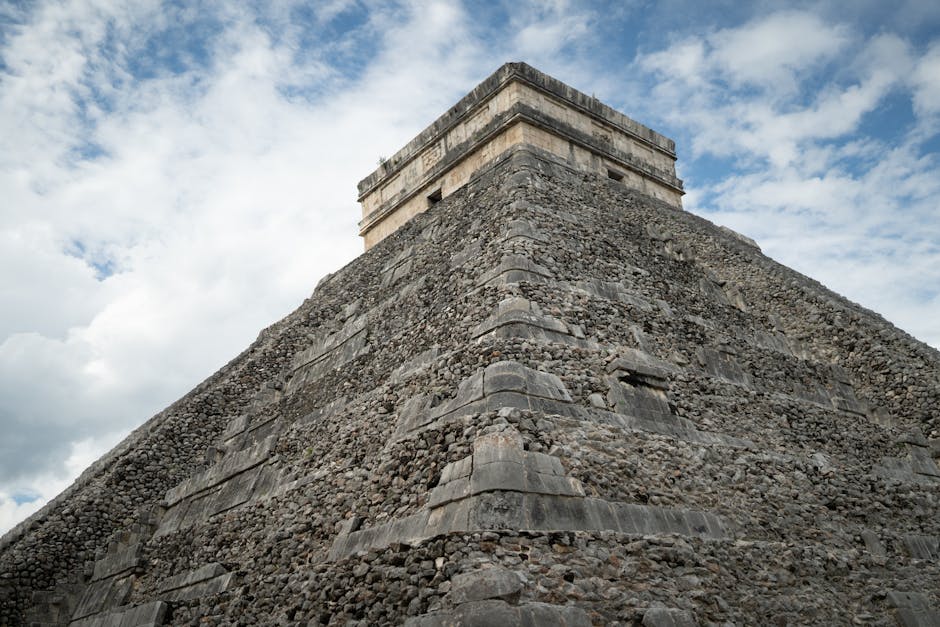 travel agent commission mayan tours - View of the Temple of Kukulcán at Chichen Itza with a dramatic cloudy sky.