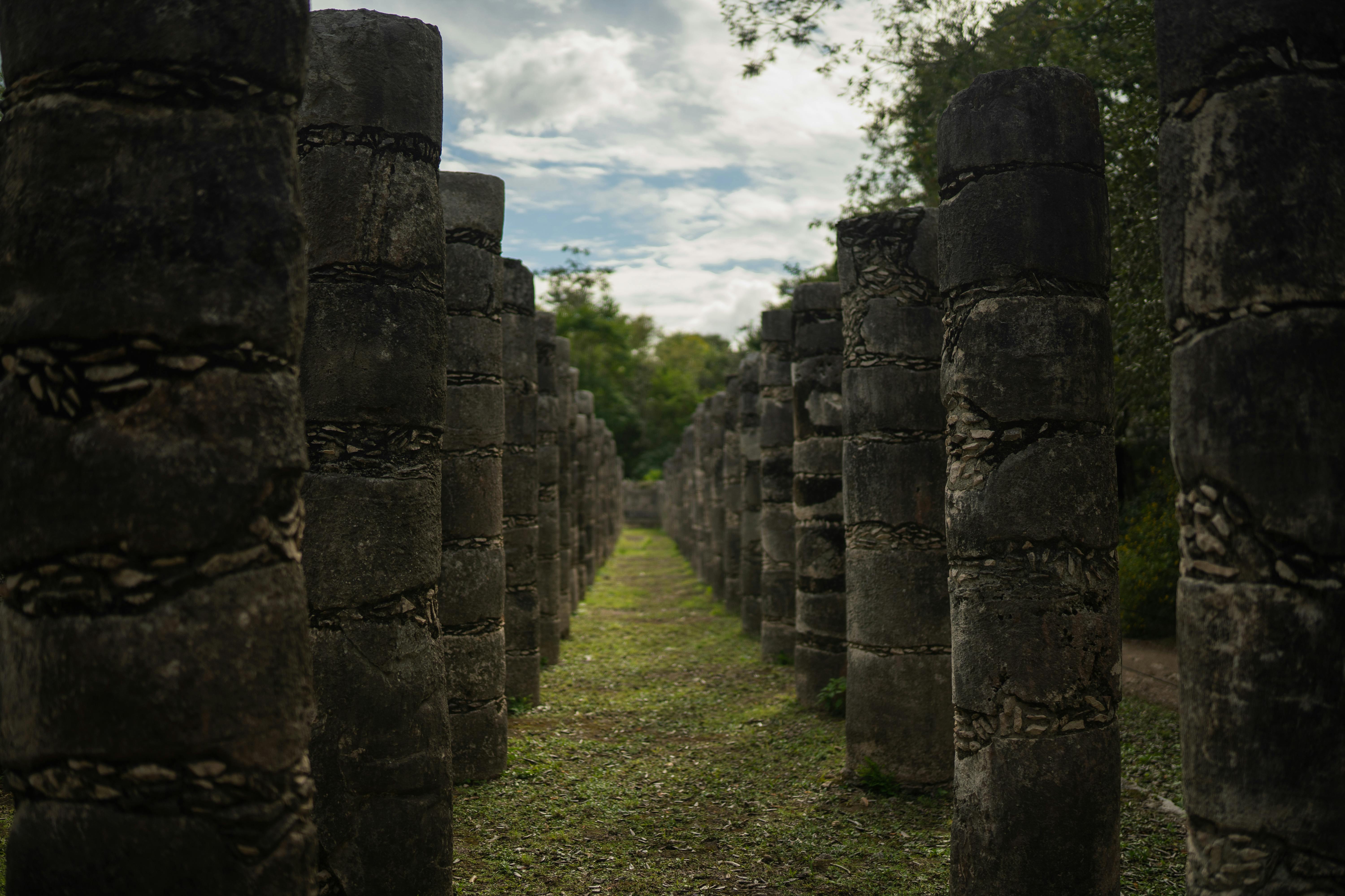 cultural immersion tours mayan civilization travel agent guide - View of ancient stone columns in a historic Mayan site, capturing timeless architecture.