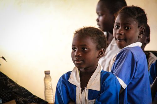 Free A group of children in school uniforms engaged in a classroom setting, focused and attentive. Stock Photo