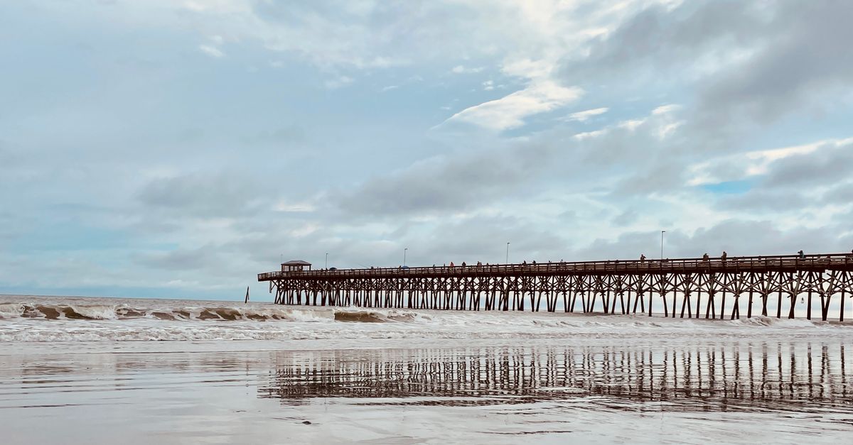 Peaceful Myrtle Beach scene with wooden pier at the seashore.