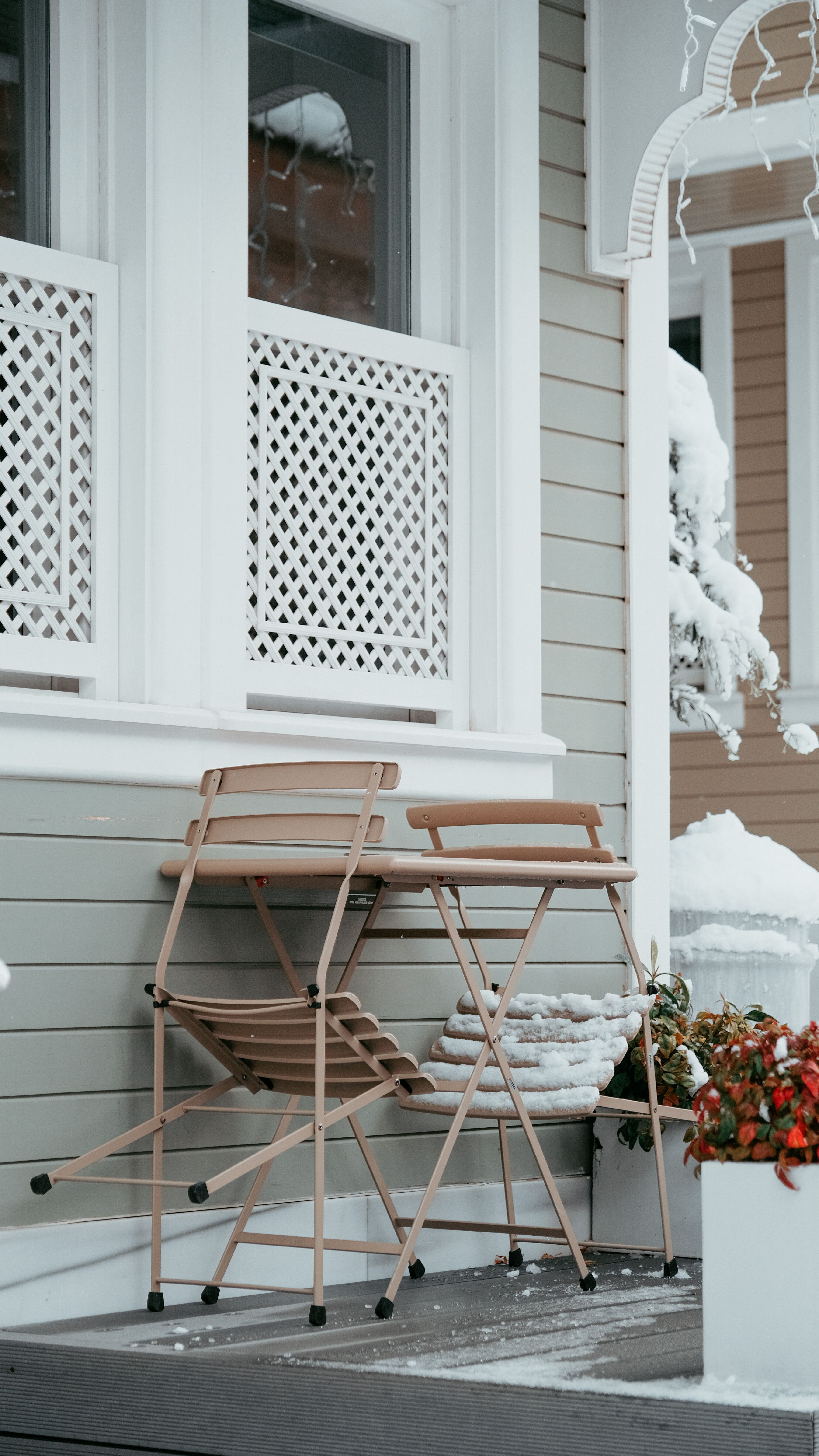 A charming outdoor café with snow-covered tables and chairs, perfect for winter retreats.
