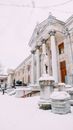 People Walking on Snow Covered Pathway Near White Concrete Building