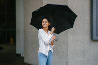 Woman in White Button-up Long-sleeved Shirt Holding Black Umbrella