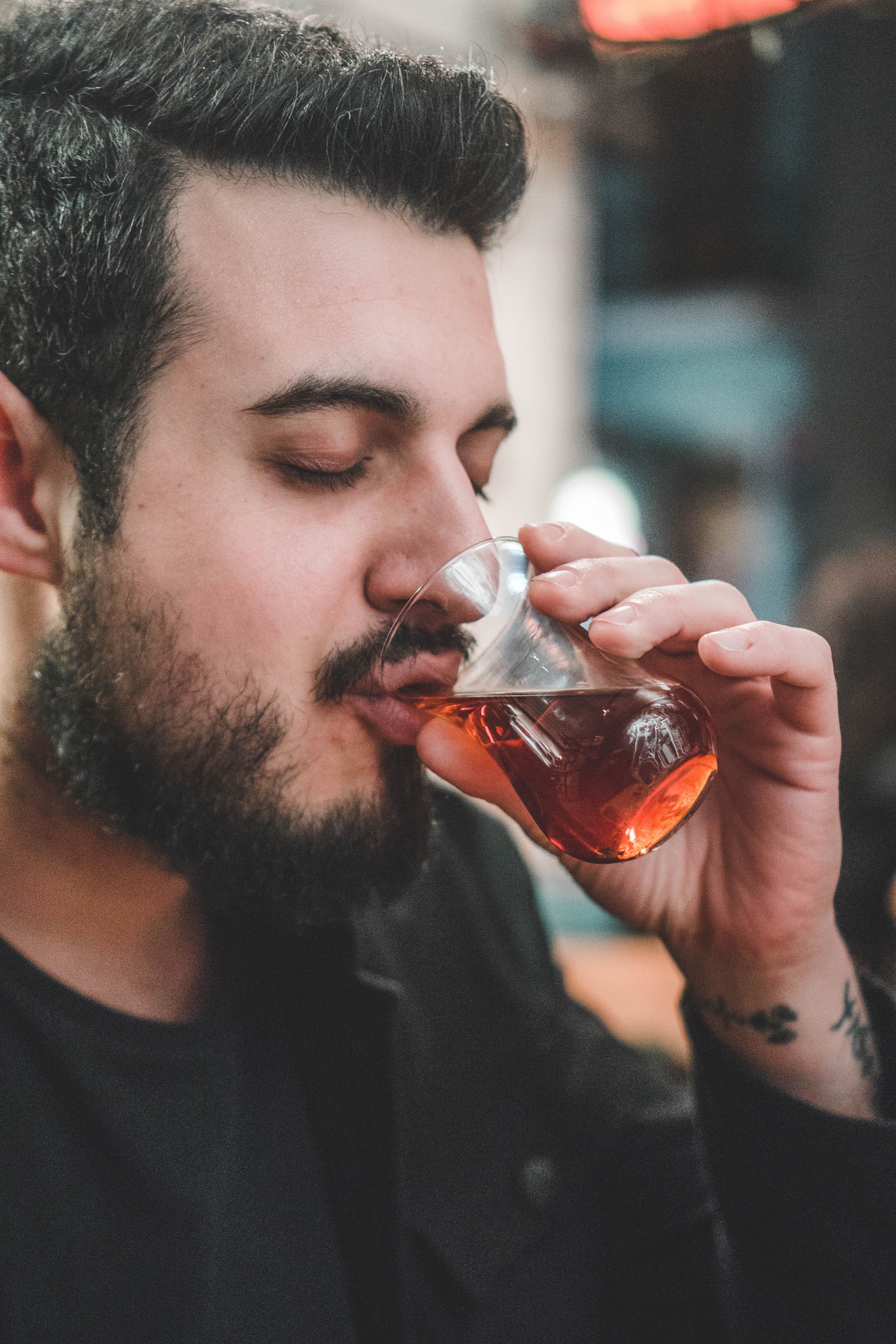 Bearded man savoring a drink in a cozy İstanbul cafe.