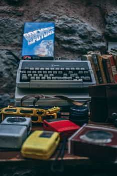 A nostalgic setup featuring a vintage typewriter and retro camera on a wooden desk.