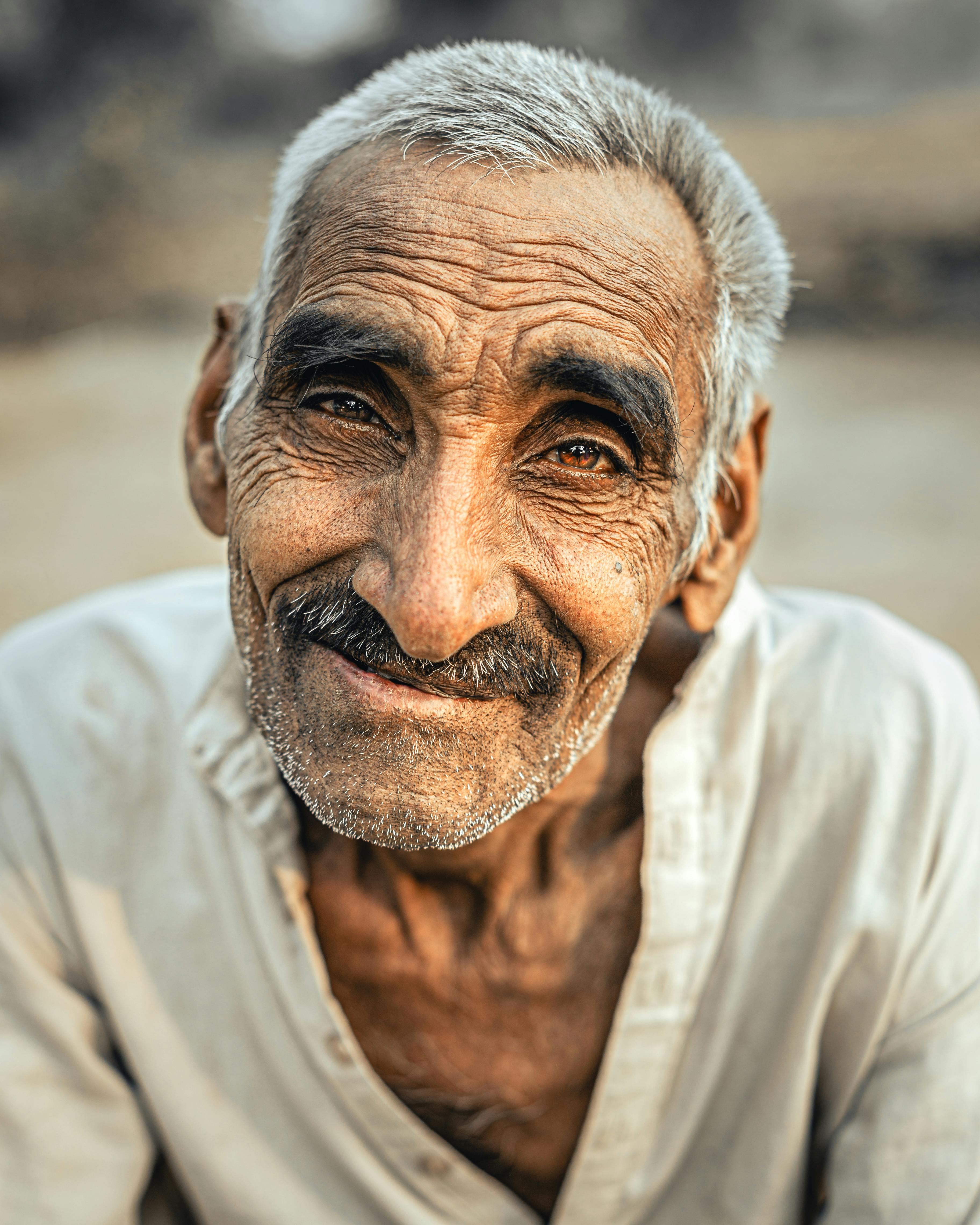 Un anciano sonríe felizmente sobre un fondo cálido estilo bokeh